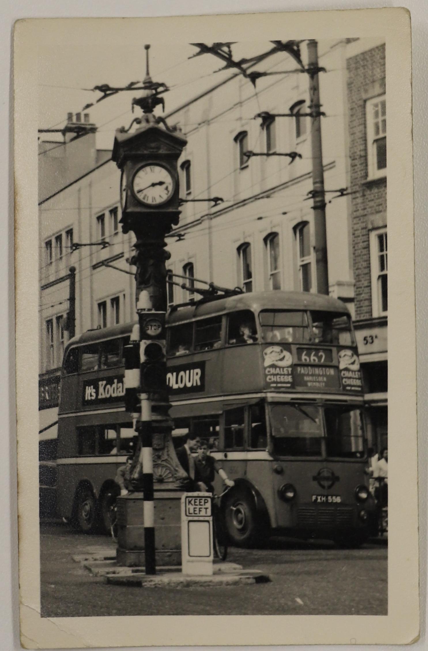 Postcard featuring a black and white image of an historic clock with a tram, number ‘662’ to Paddington, behind it.